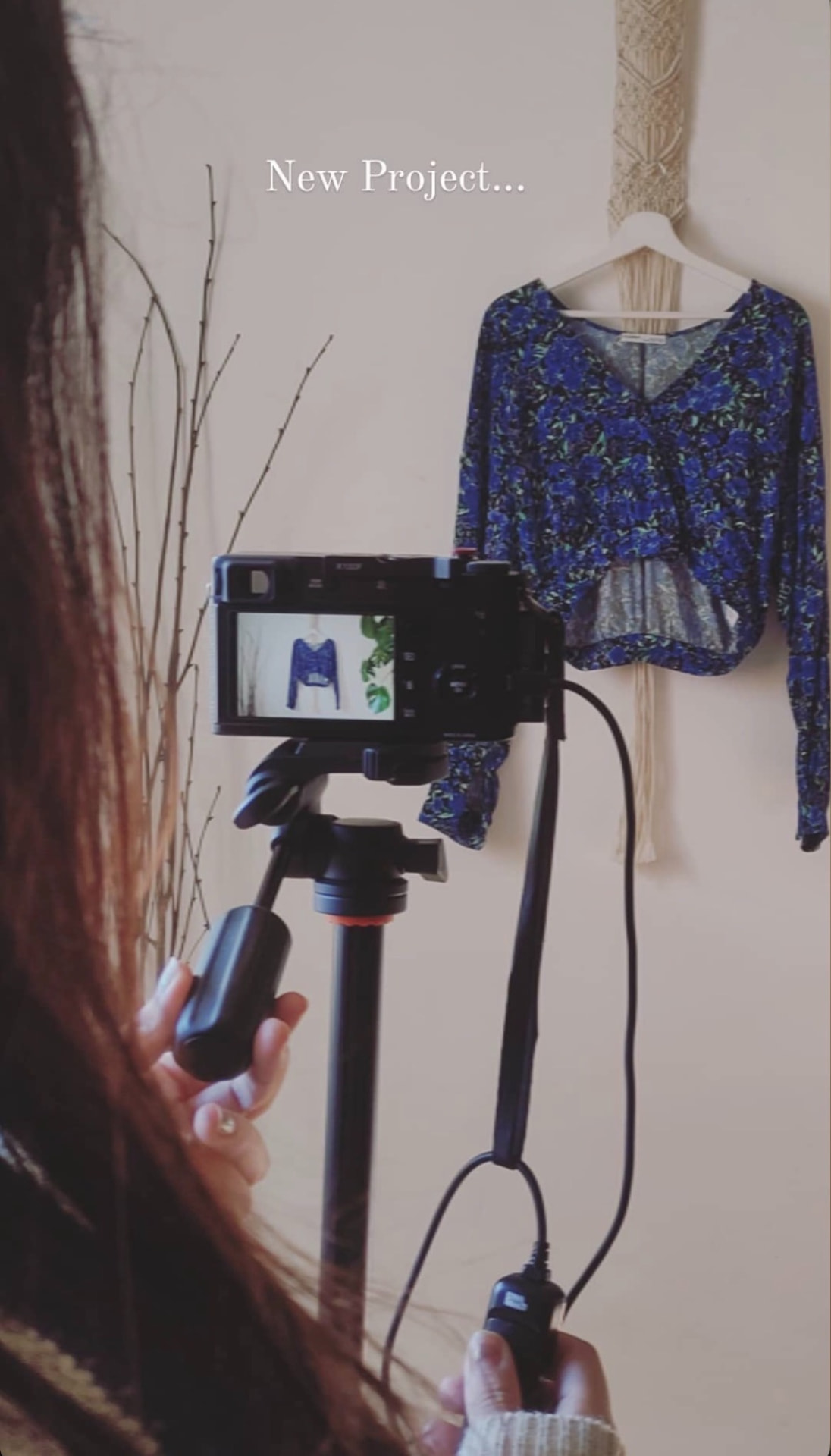 Maya photographing an upcycled floral blouse for UpHand.