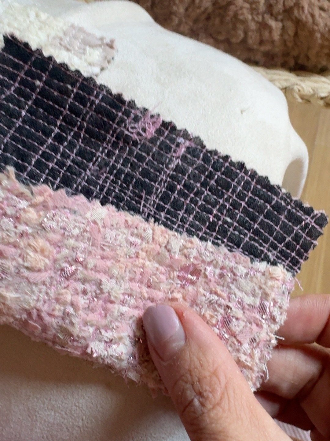 Pink and black stitched TexCell samples held against fabric.