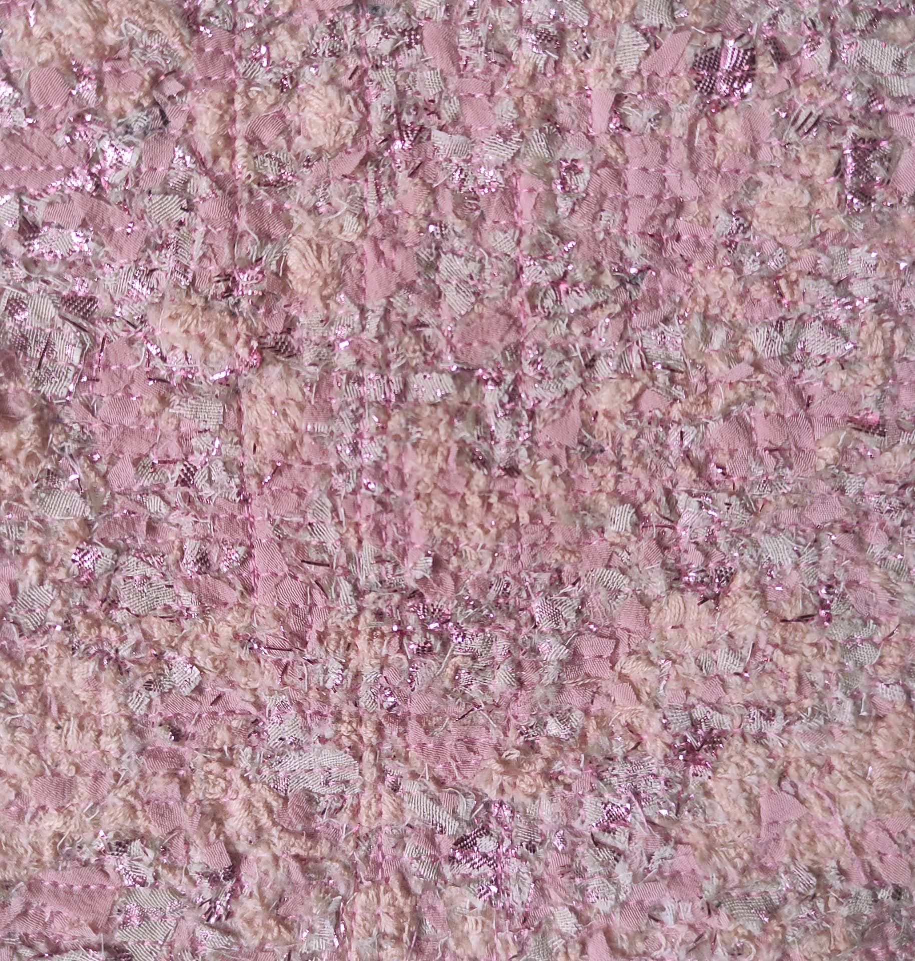 Close-up of the pink TexCell surface: recomposed textile fragments bonded and stitched into a tweed-like material.